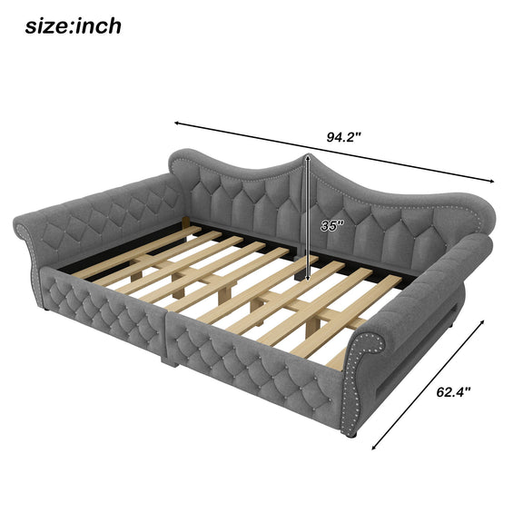 Tufted upholstered daybed with dark fabric, curved arms, slatted base, stud trim