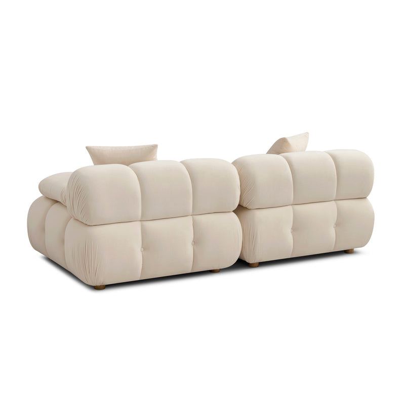 Light beige modular loveseat sofa with tufted cushions, rounded arms, and two back pillows