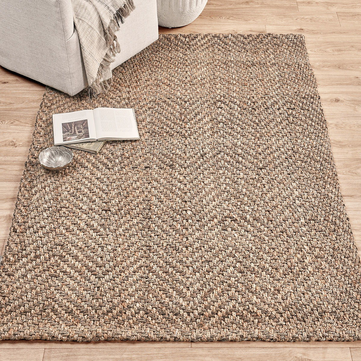 Jute herringbone rug with textured chevron weave in natural beige and light speckling.