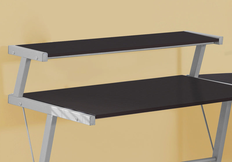 Corner L-shape desk top and lower shelf detail, dark brown surfaces, gray metal supports