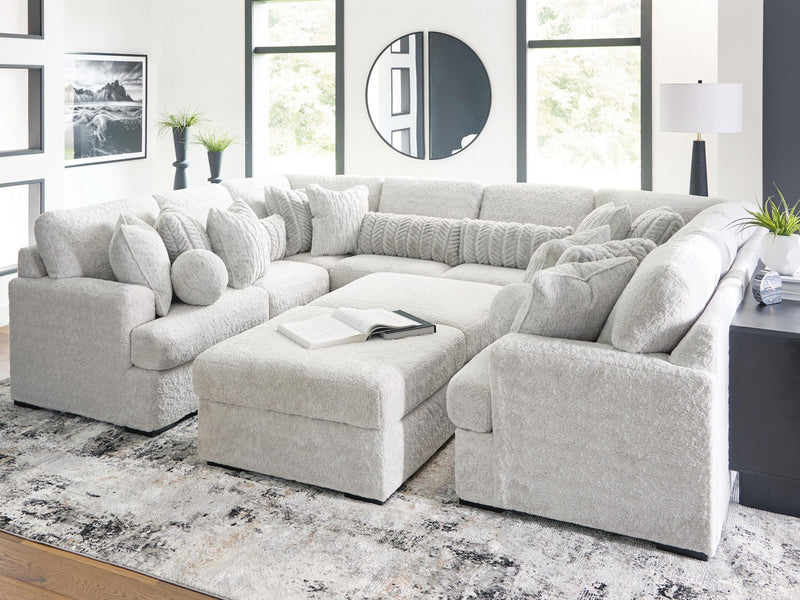 White sectional sofa with long chaise and ottoman-style seats with plush cushions