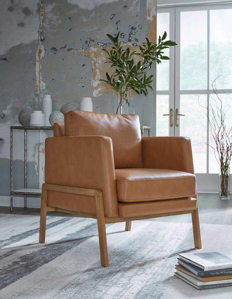 Caramel accent chair in a living space, with padded arms, seat, and wooden legs