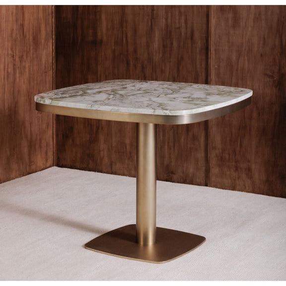 Corner view of round cafe table with green marble-look top and antique brass base