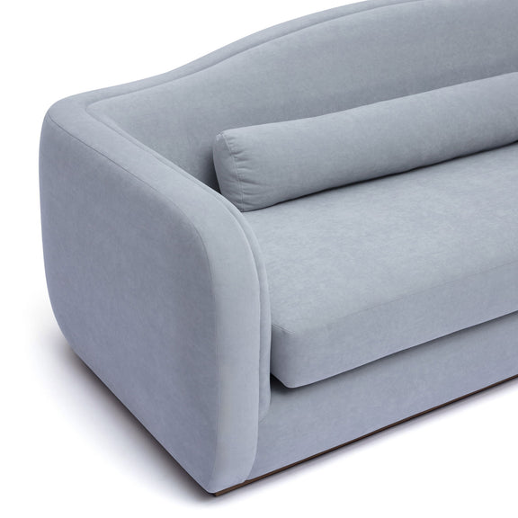 Light blue upholstered sofa with rounded arms and snug back cushion