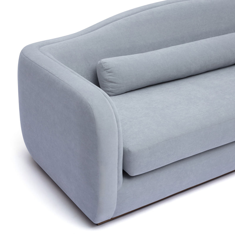 Light blue upholstered sofa with rounded arms and snug back cushion