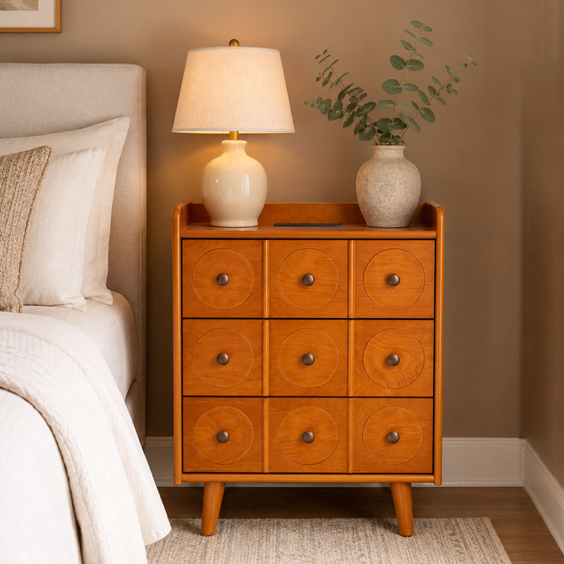 Natural wood end table with nine drawers, lamp on top, tapered legs