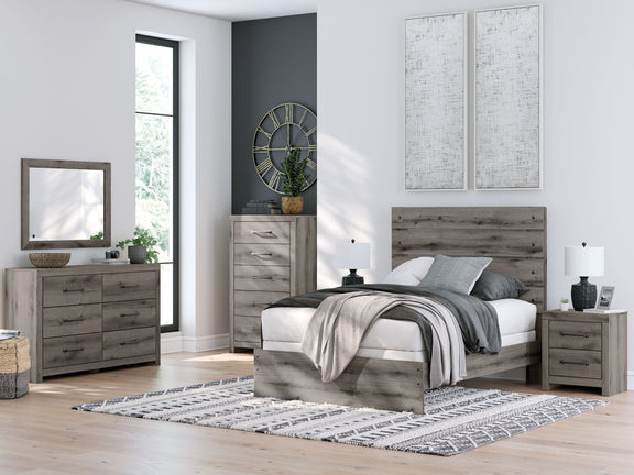 Rectangular wall mirror with dark gray wood frame in a bedroom setting