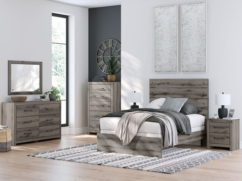 Rectangular wall mirror with dark gray wood frame in a bedroom setting