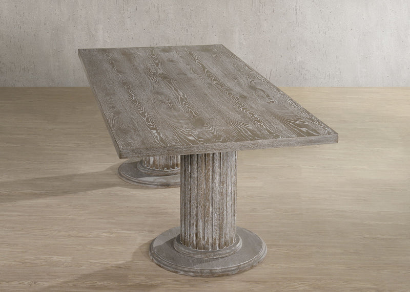 Reclaimed wood dining table with slanted top and round pedestal base, beige-gray finish.