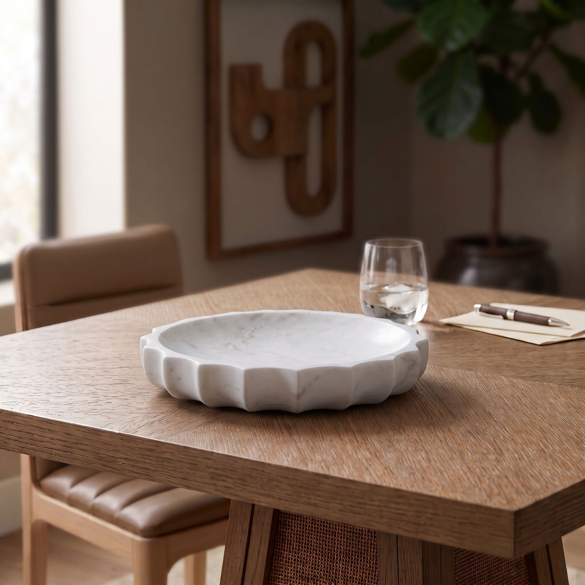 White marble bowl on a table, rounded scalloped edge with veined pattern