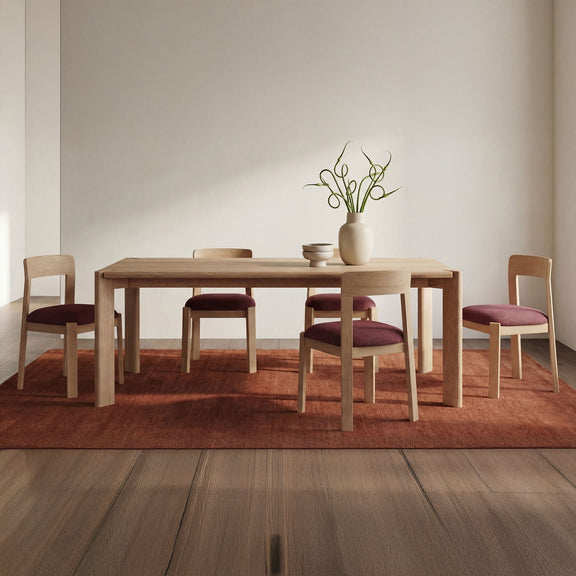 Berry purple upholstered dining chairs with light wood frames, styled around a table