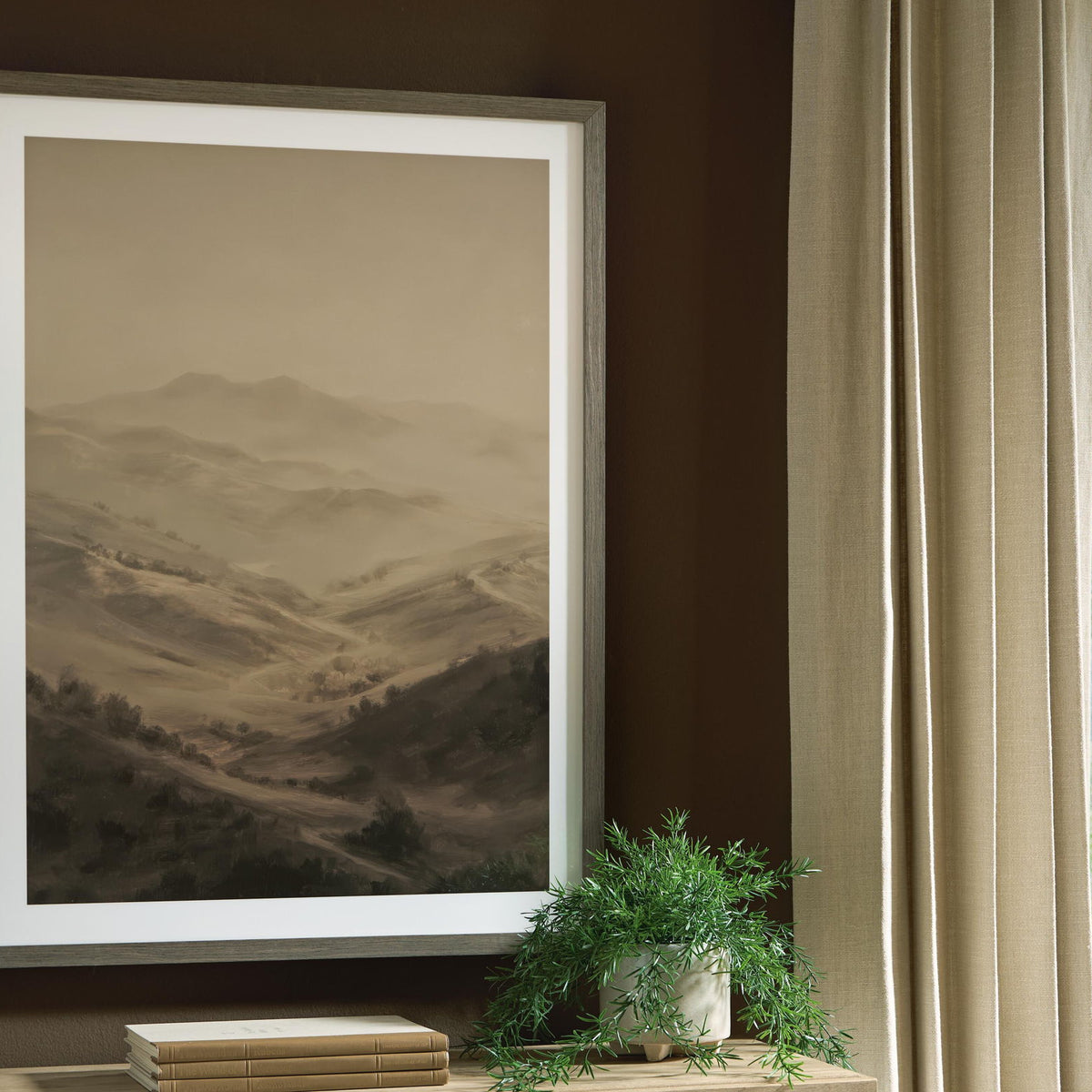 Framed landscape wall art with brown desert hills, hanging on a wall
