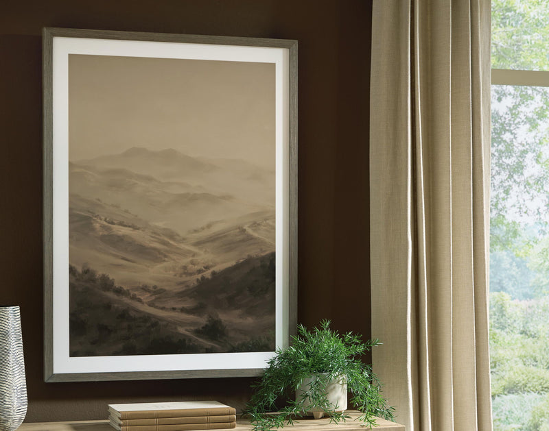 Framed landscape wall art with brown desert hills, hanging on a wall