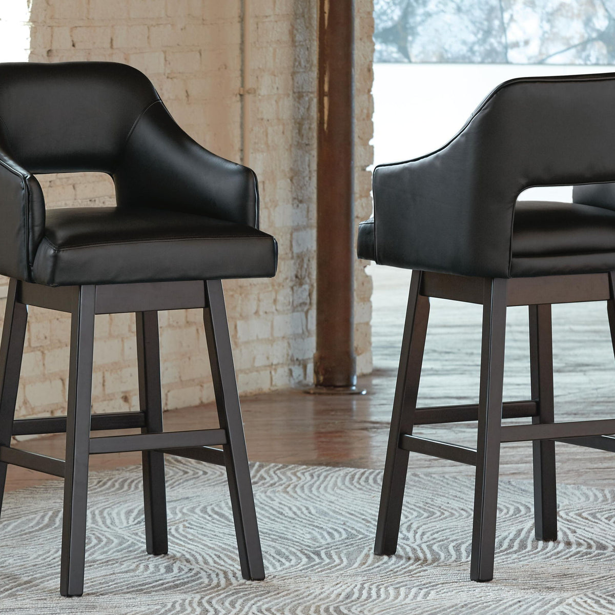 Two black upholstered swivel barstools, padded arms, sturdy straight legs
