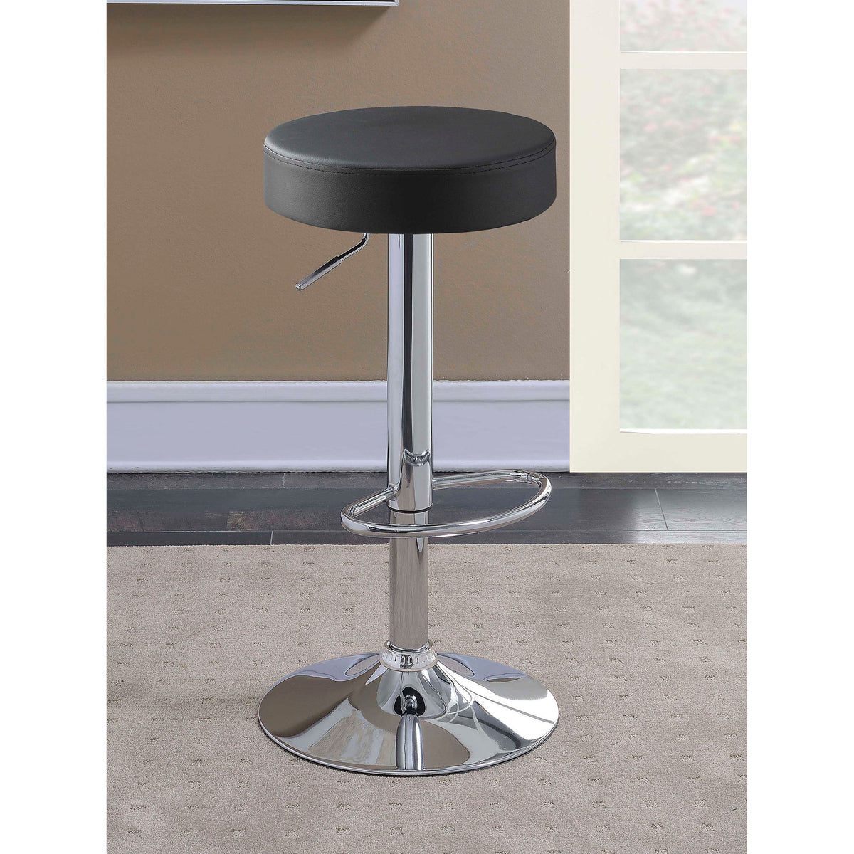 Black padded bar stool seat with chrome pedestal and circular footrest ring.
