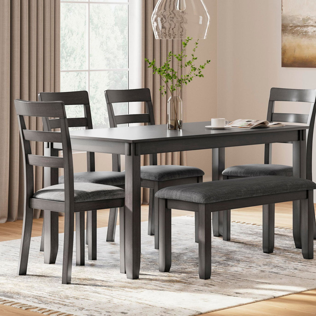 Gray rectangular dining table with matching upholstered chairs in a home dining setup