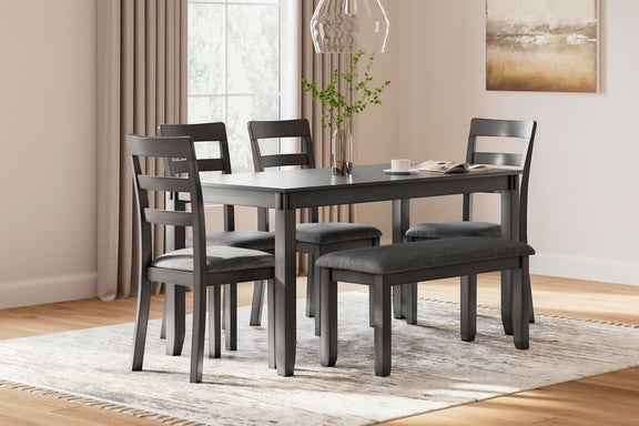 Gray rectangular dining table with matching upholstered chairs in a home dining setup