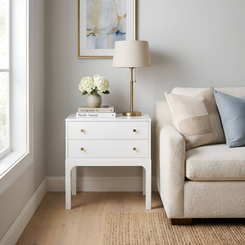 White two-drawer nightstand with brass knobs and a flat top surface.