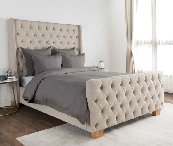 Dove gray pillow sham on bed with tufted headboard and matching bedding