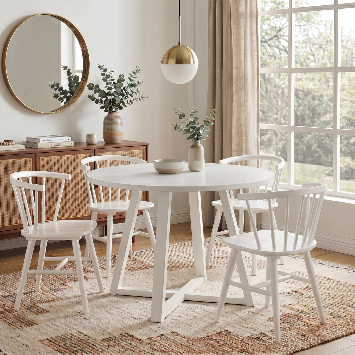 White round trestle dining table with four spindle-back Windsor chairs