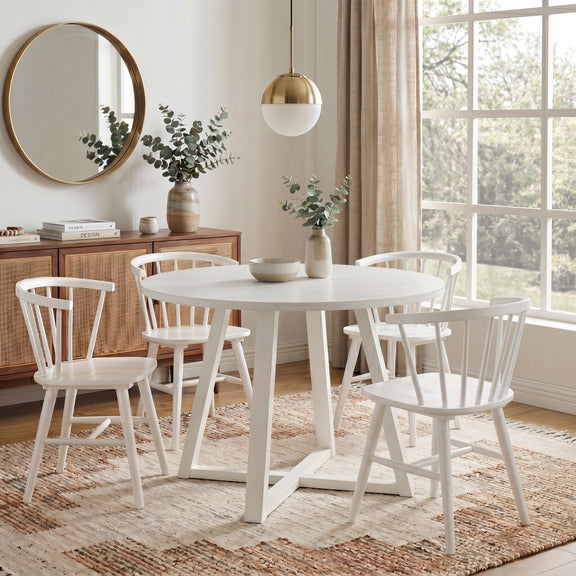 White round trestle dining table with four spindle-back Windsor chairs