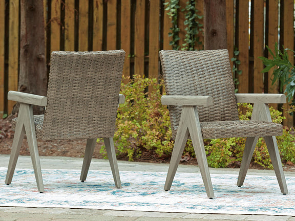 Outdoor beige woven armchairs with light wood arms, matching seat and back