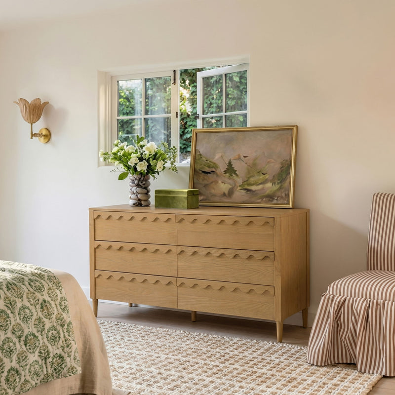 Light brown 6-drawer dresser with wavy drawer fronts, styled in a bedroom corner