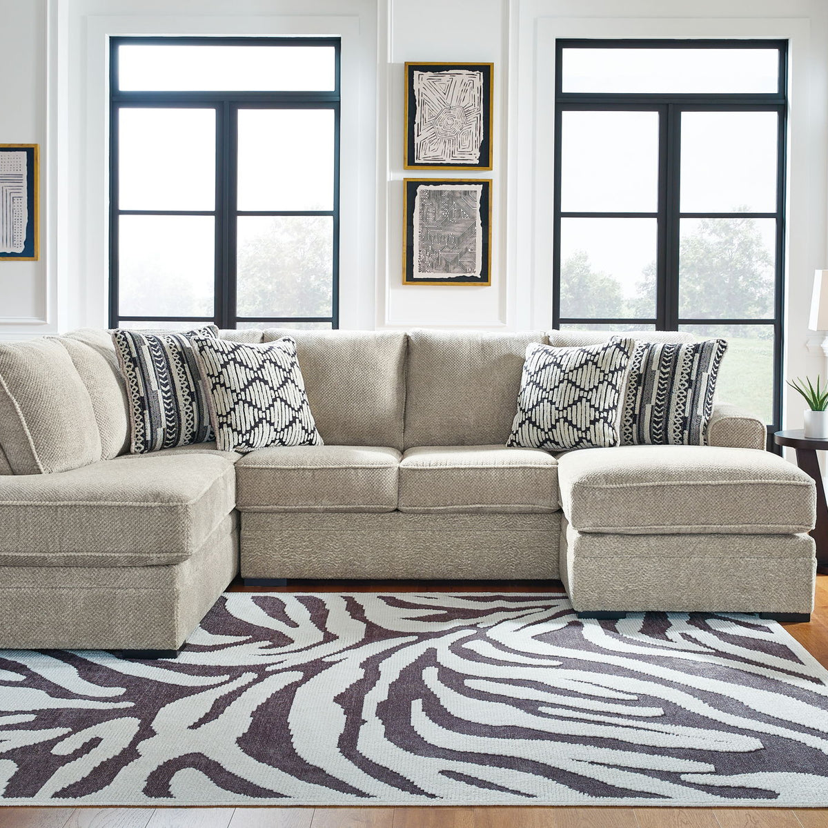 Beige corner chaise sectional sofa with patterned pillows and chaise ottomans