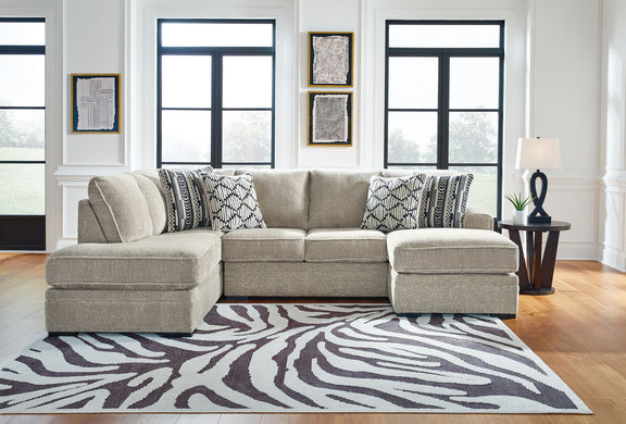 Beige corner chaise sectional sofa with patterned pillows and chaise ottomans