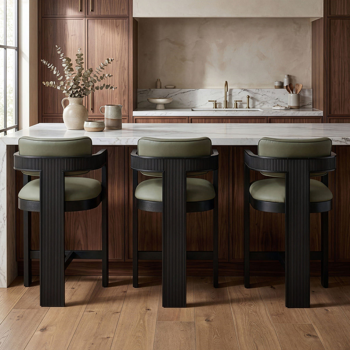 Set of 3 vegan leather counter stools with light green upholstered seats and black ribbed bases