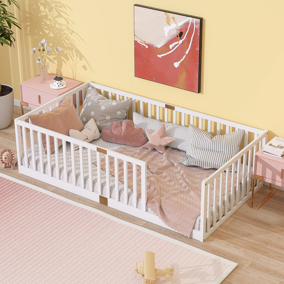 White twin floor bed with tall safety guardrails, wooden slats; styled with bedding.