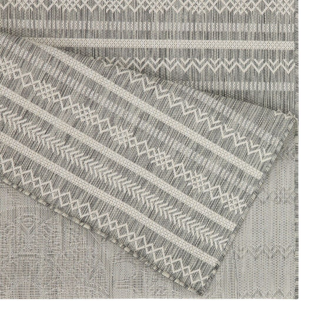 Indoor/outdoor area rug corner detail with gray stripes, chevrons, and textured pattern
