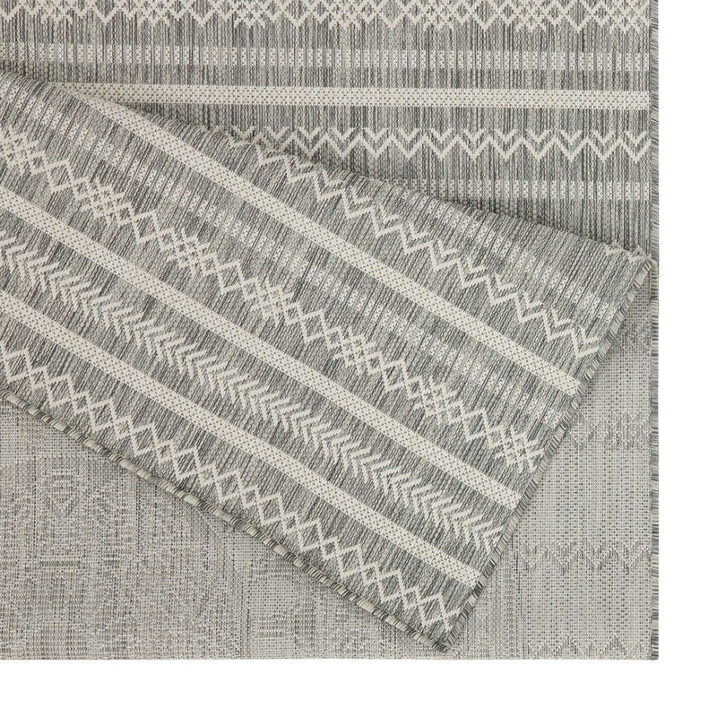 Indoor/outdoor polypropylene rug corner with gray and white striped woven pattern