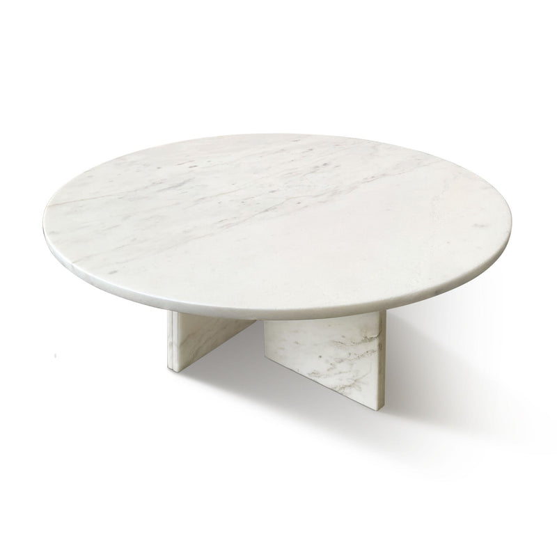 Round white marble coffee table with triangular stone base and clean veining