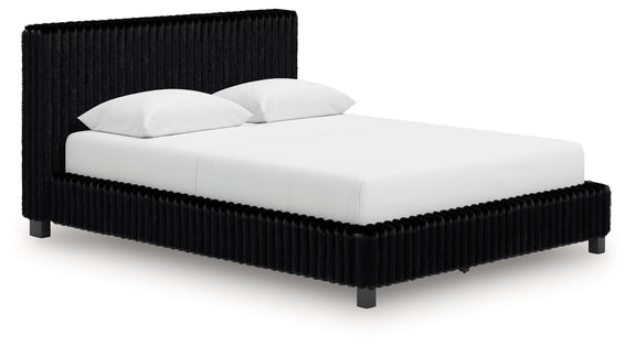 Black upholstered bed with ribbed headboard, squared sides, and white bedding.
