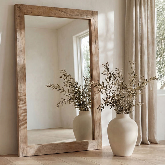 Reclaimed wood floor mirror with rectangular frame, natural grain, standing beside vases