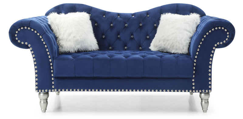Dark blue tufted round-arm loveseat with studded trim, fur pillows, and silver legs