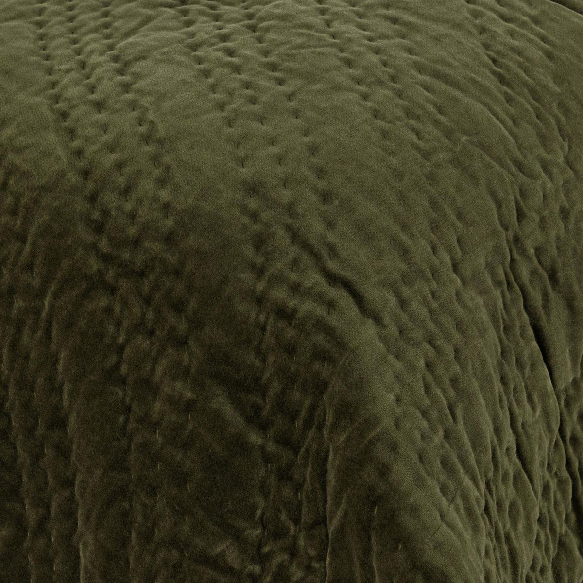 Dark green velvet quilt with raised diamond quilting texture close-up