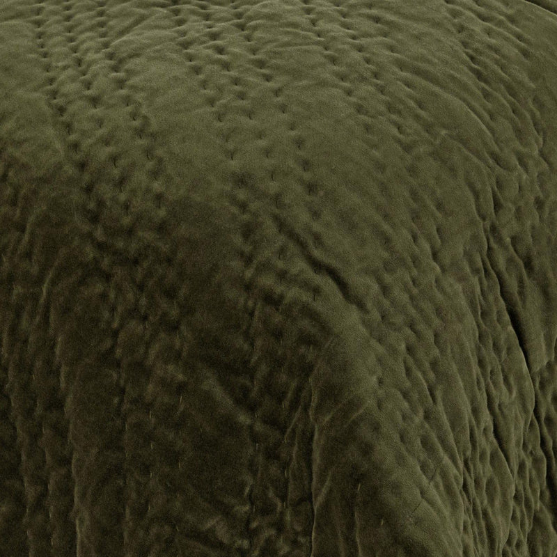 Dark green velvet quilt with raised diamond quilting texture close-up