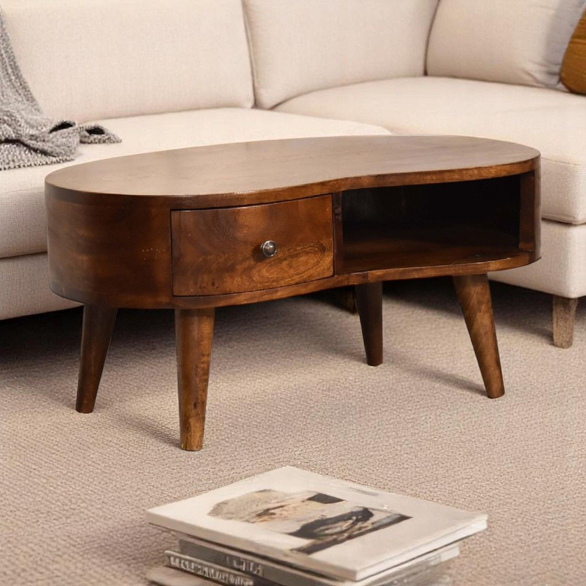 Wave coffee table with drawer, dark brown round top, open storage bay, tapered legs.