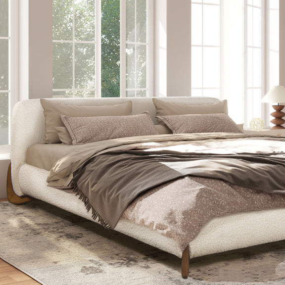 White upholstered modern platform bed with curved headboard and wooden tapered legs