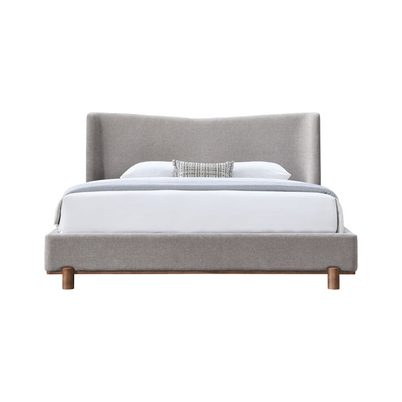 Gray upholstered bed with tall headboard and white pillow, wooden legs