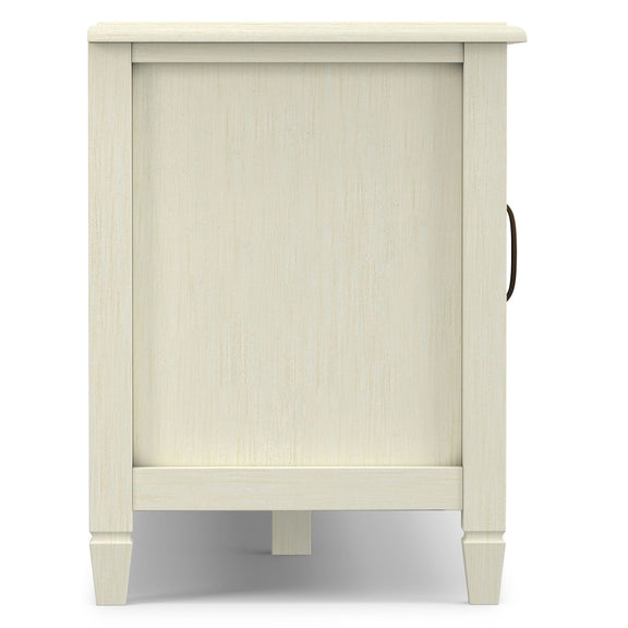 White wide TV stand with paneled front, legs, and cable cutout