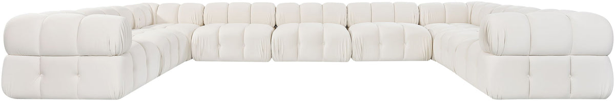 White velvet sectional with tufted cushions, L-shaped chaise, and rounded arms