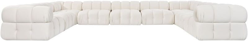 White velvet sectional with tufted cushions, L-shaped chaise, and rounded arms