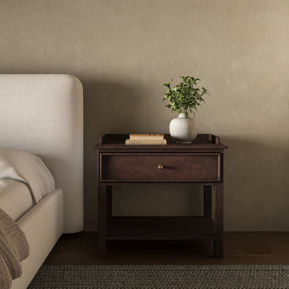 Front view of a dark brown nightstand with a drawer, brass knob, lower shelf and raised top edge