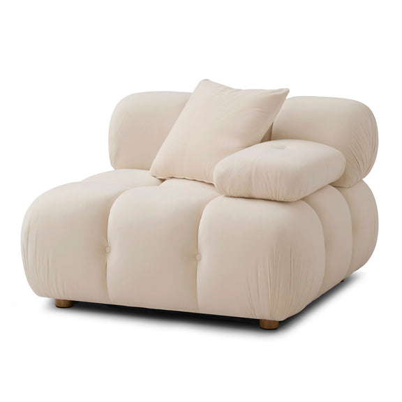 Light cream corner chair with layered pillows, rounded arms, and tufted cushion panels
