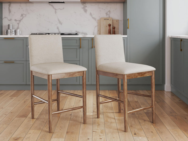 Two beige upholstered barstools with light brown wooden legs and built-in footrests