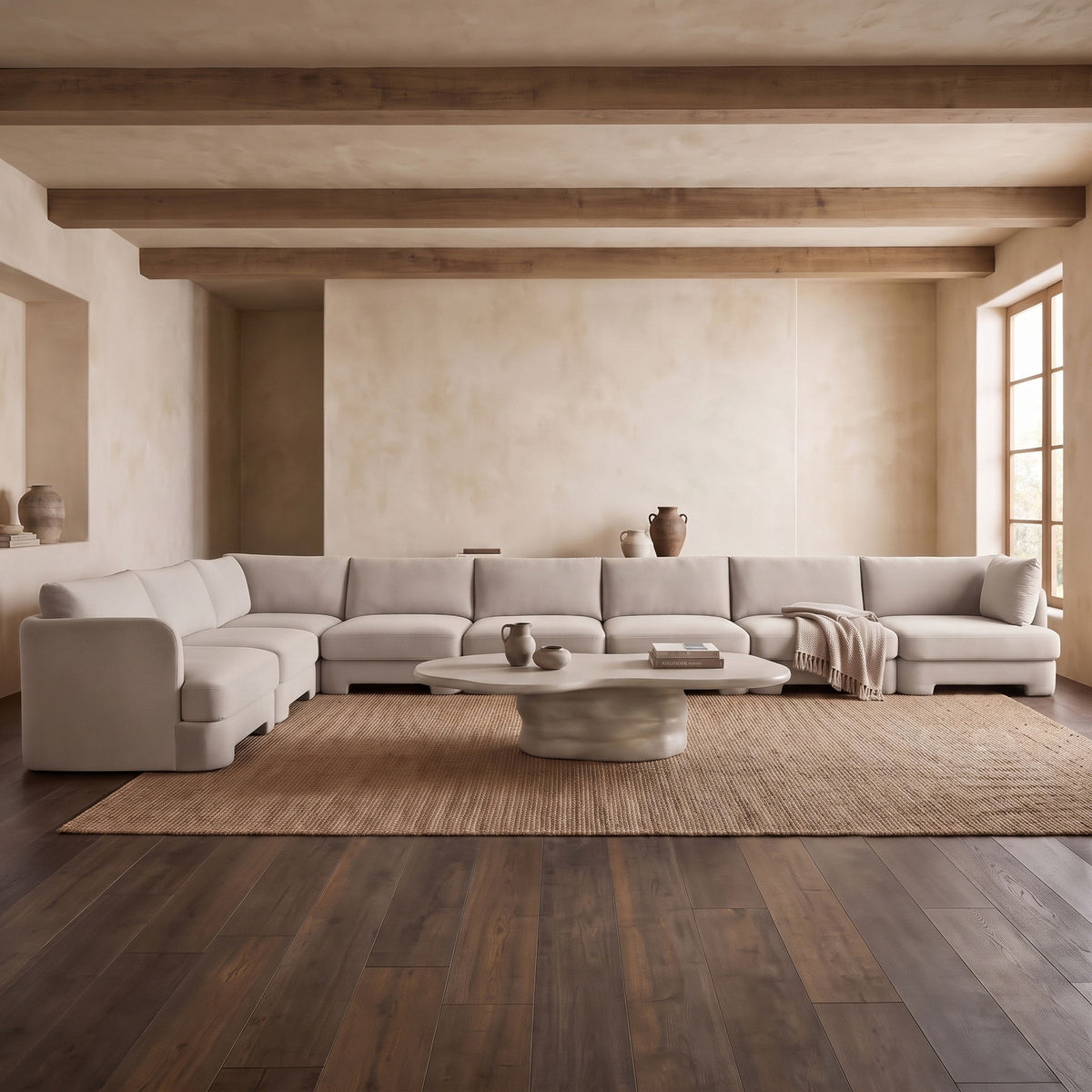 Gray velvet L-shaped sectional sofa with chaise seating and center ottoman