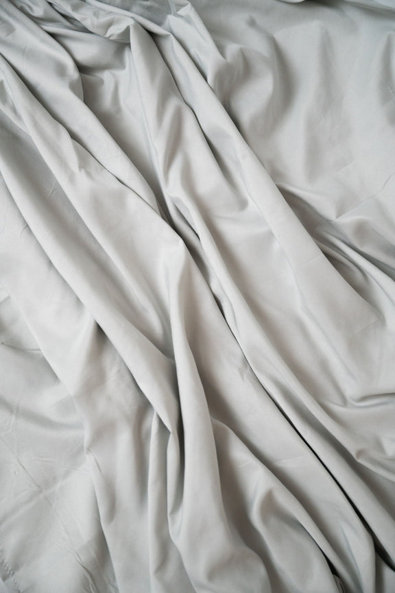 Gray microfiber and bamboo sheet fabric close-up with visible seam
